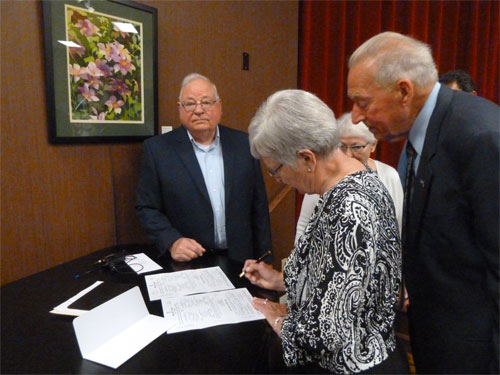 Photo of Dianne signing wedding certificate