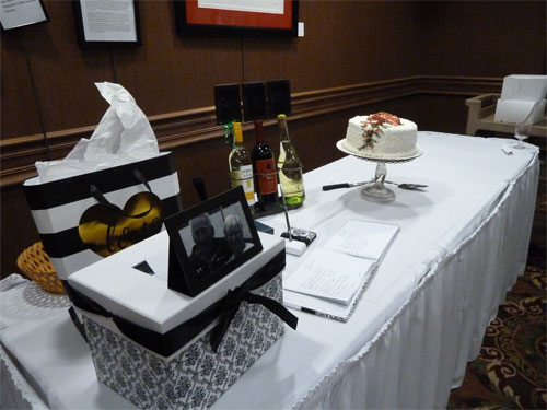 Photo of table with guest book, card box, and cake
