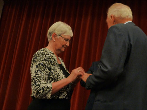 Photo of Dianne placing ring on Bob's finger
